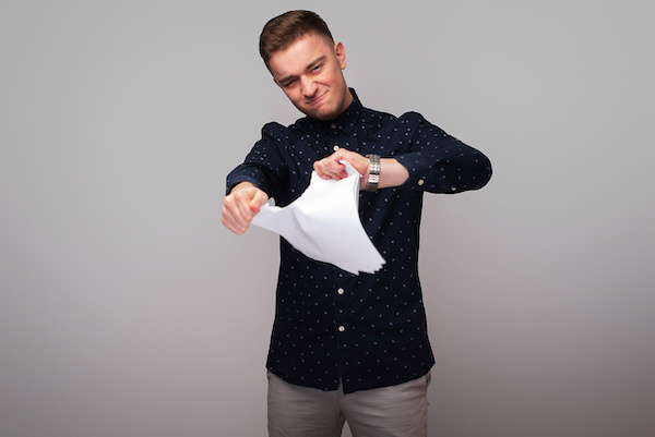 man tearing paper